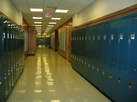 Does which High School you attend matter in College Admissions? School hallway with blue lockers along walls.